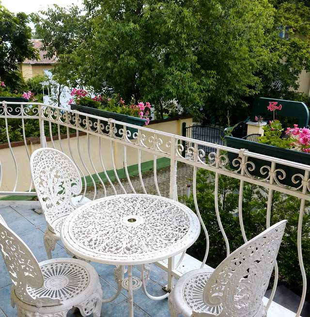 Sun terrace with seating beside the garden at Villa Kristal Hotel