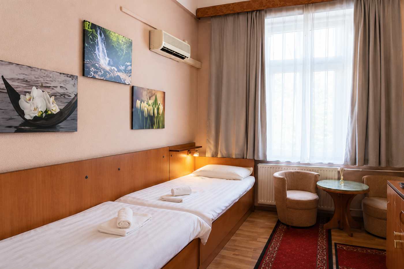 Twin room with two beds and a work desk at the hotel in Buda
